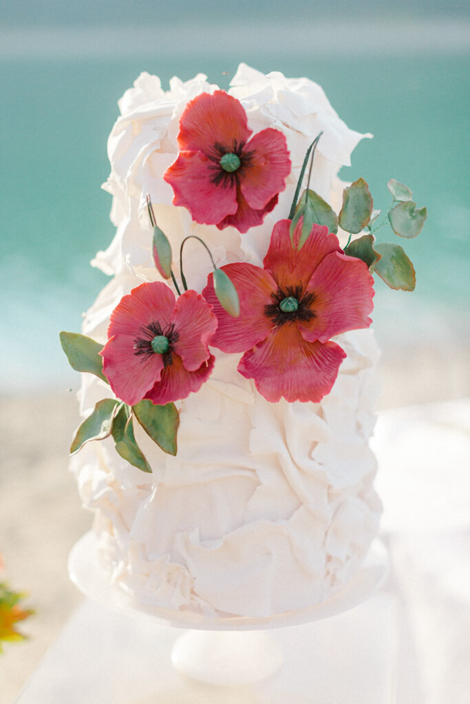 Unique textured two-tiered textured wedding cake, with pink and red cascading sugar poppies, created by Chartier YYC, elegant cakes & desserts in Calgary, AB, featured on the Brontë Bride Vendor Guide.