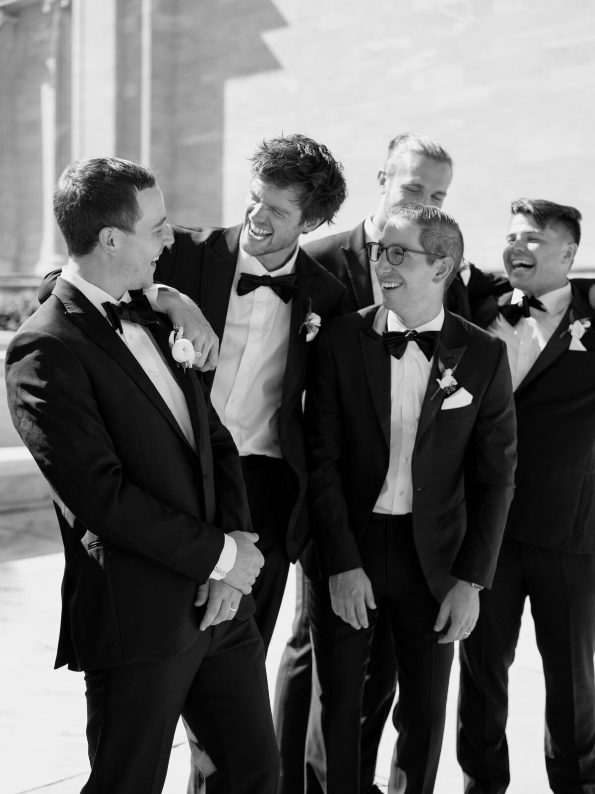 Groom laughing with groomsmen walking at Cleveland Art Museum