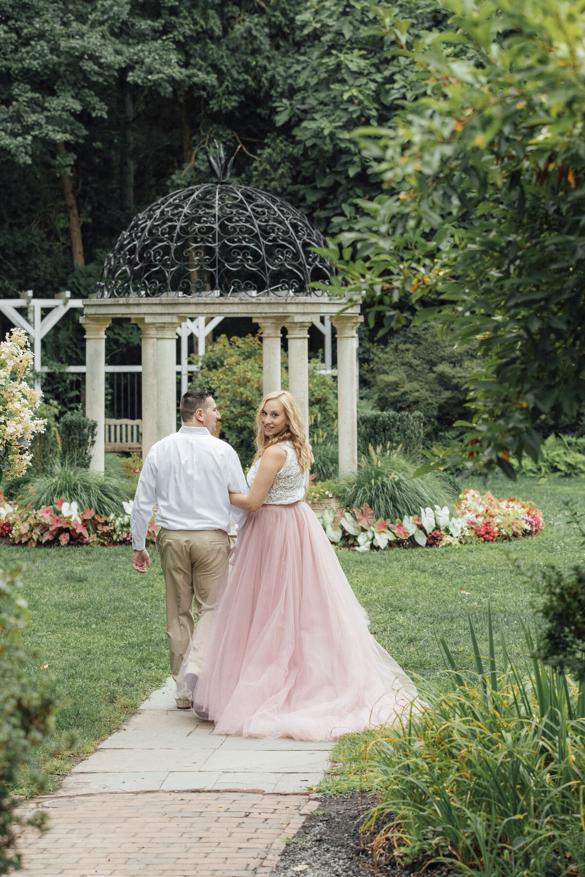 Couple posing by gazebo during summer pre-wedding photos at Sayen House and Gardens in Hamilton Township New Jersey