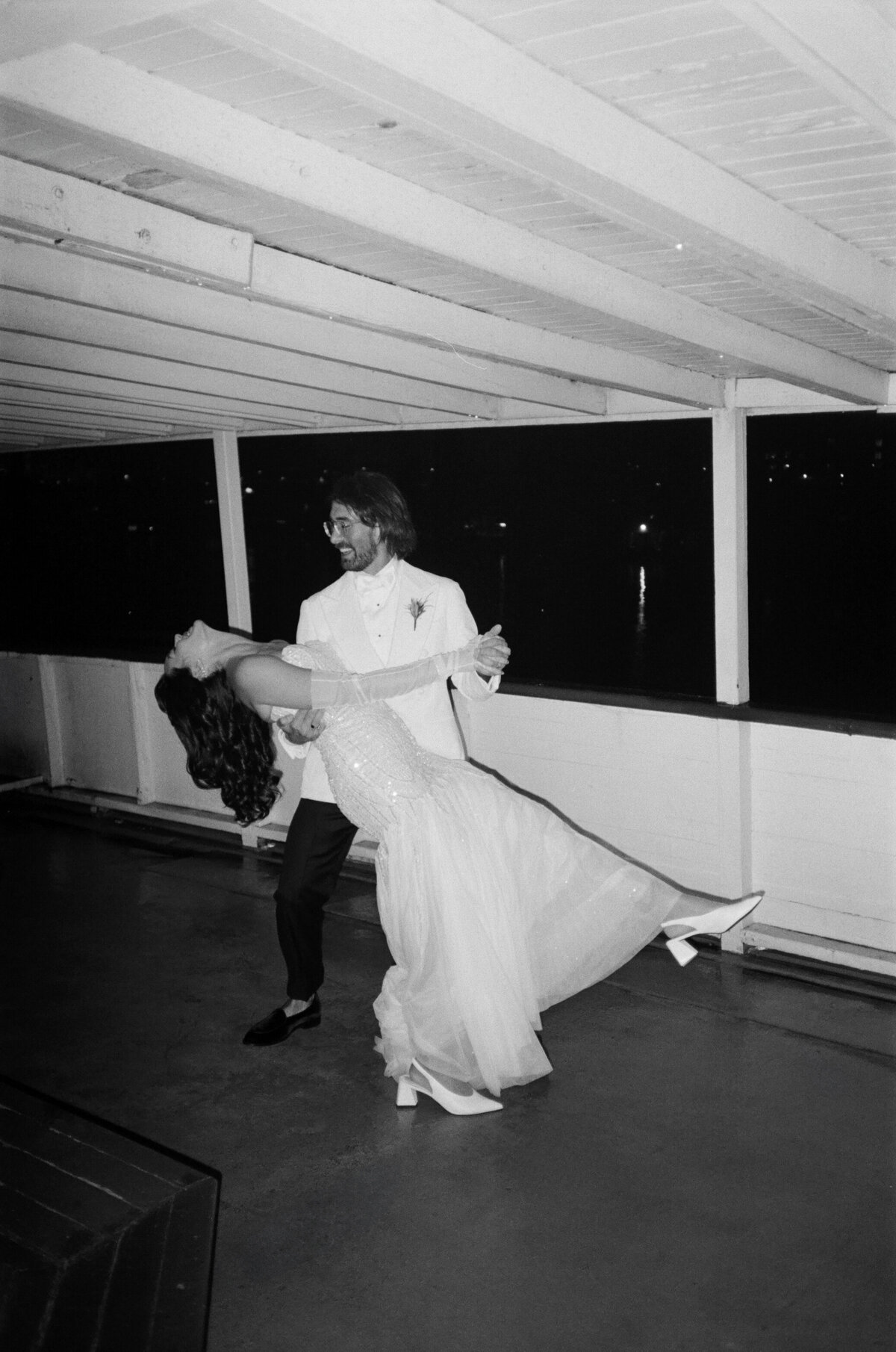 Groom dipping bride on the deck of the MV Skansonia in Seattle, Washington.