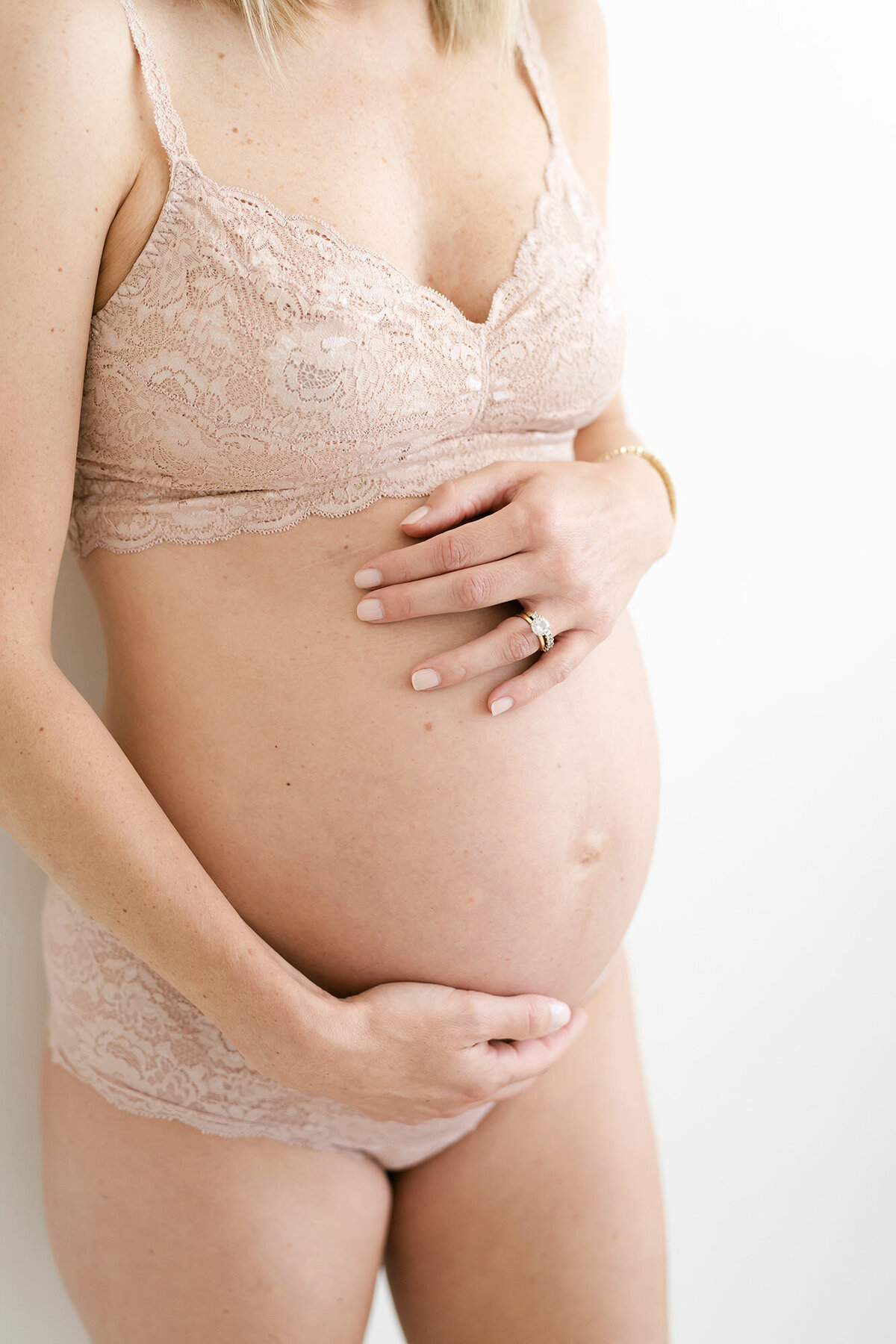 Louisville boudoir maternity photography of mom in bra and underwear holding belly