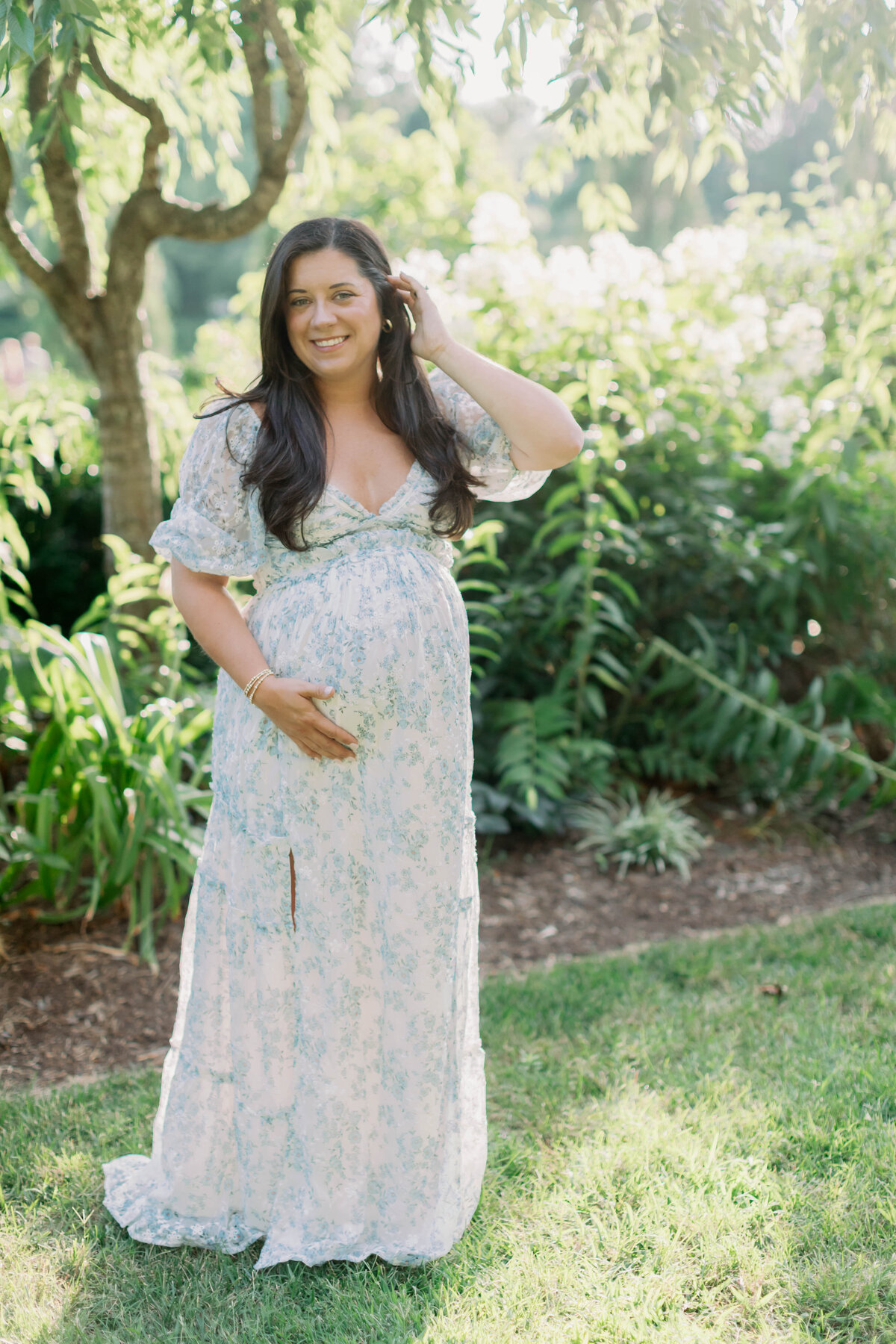 pregnant mom holding her tummy in a garden