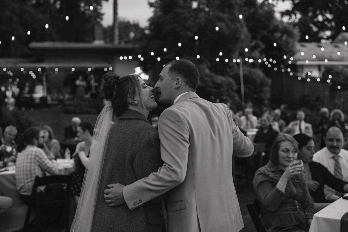 Bride and Groom give thank you speech backlit by twinkle lights
