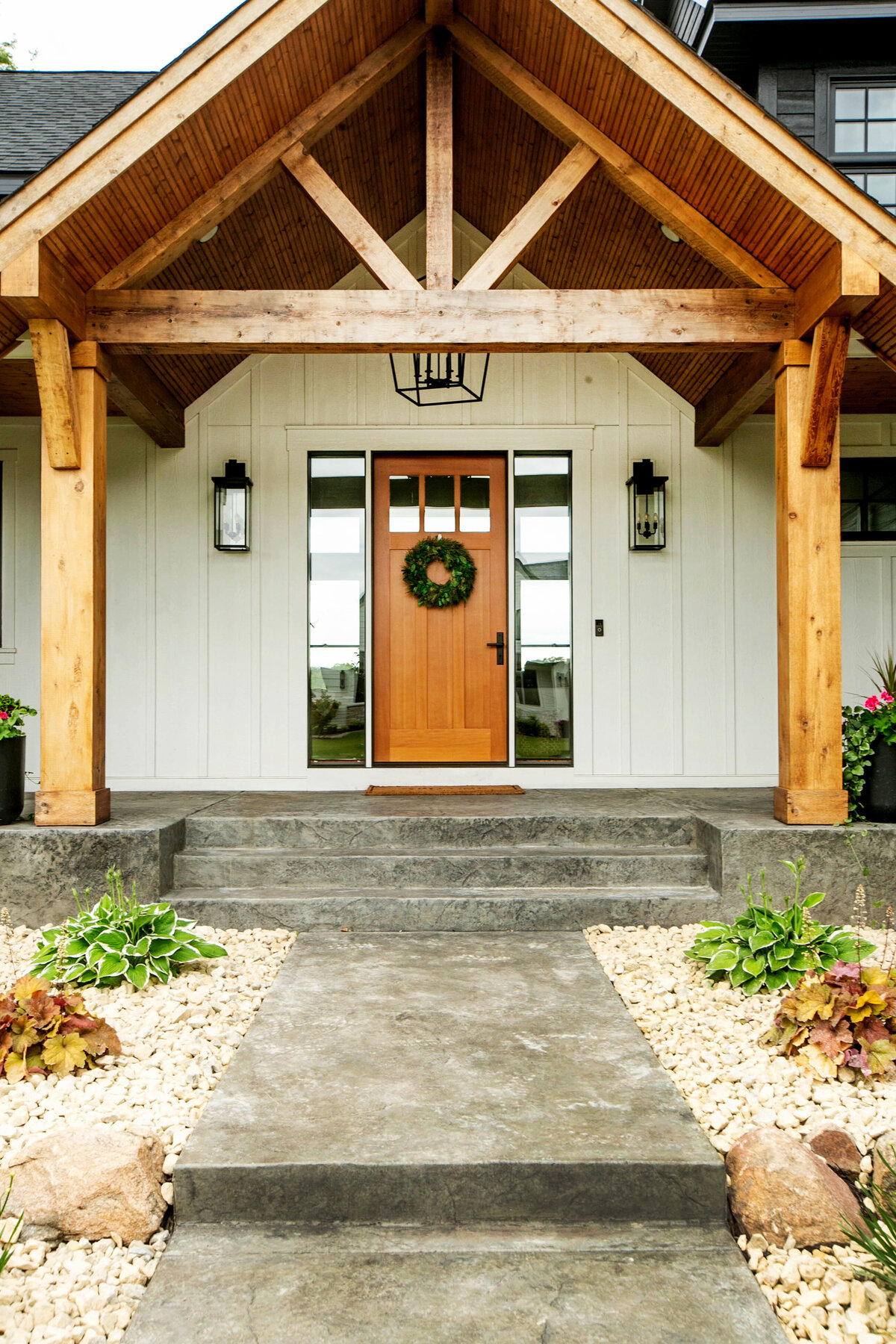 Exterior view of custom home in Otsego, Minnesota with modern wood details and front porch built by Cornerstone Custom Builds