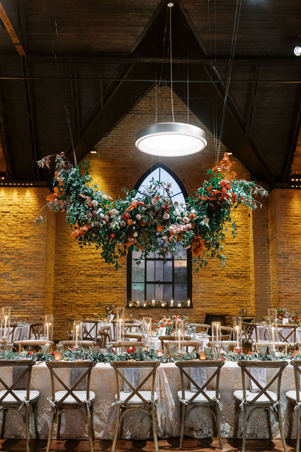 Gorgeous hanging installation of fall foliage, lush greenery and florals over the ceremony turned reception space enhancing the warm, natural atmosphere. Designed by Rosemary and Finch in Nashville, TN.