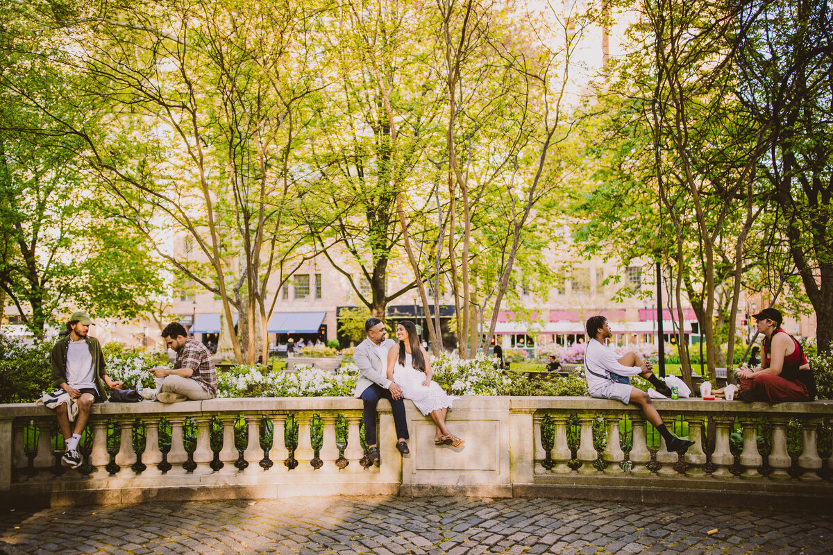 A couple sitting on a ledge sharing a moment at the rittenhouse square park in philadelphia