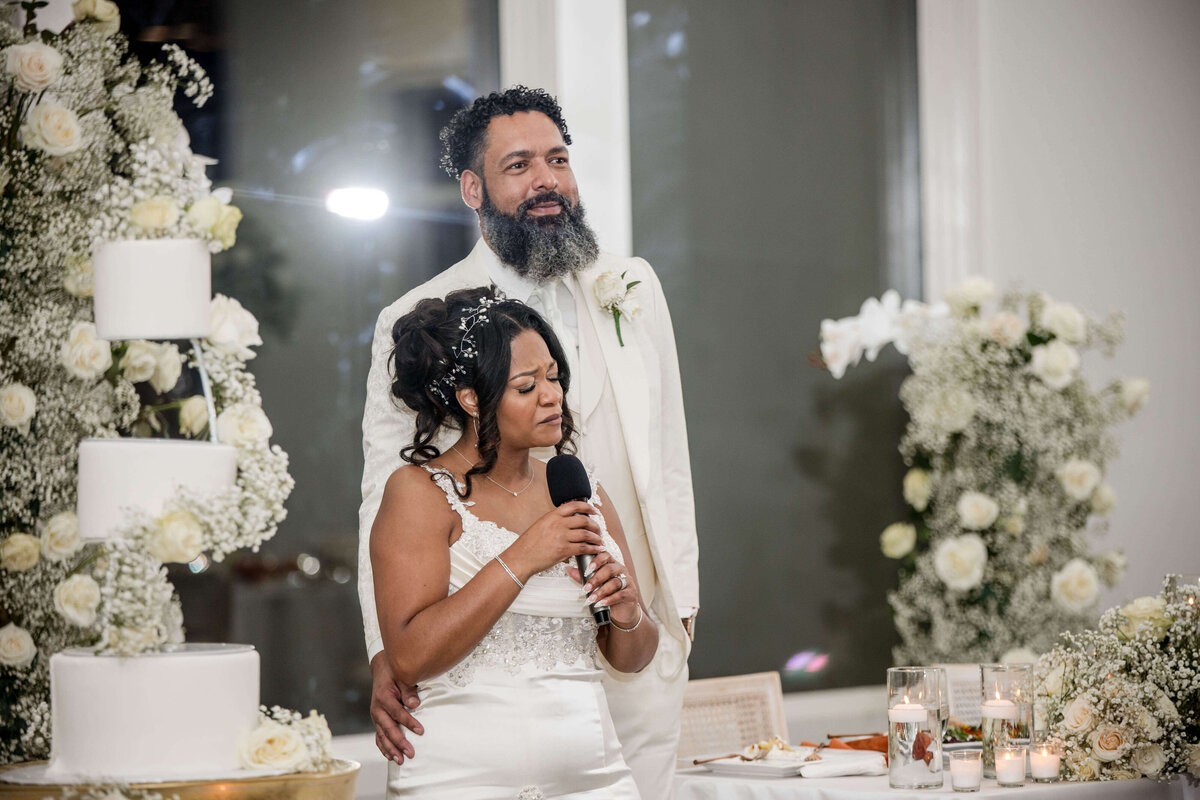 The couple stands together as they listen to heartfelt speeches from loved ones.