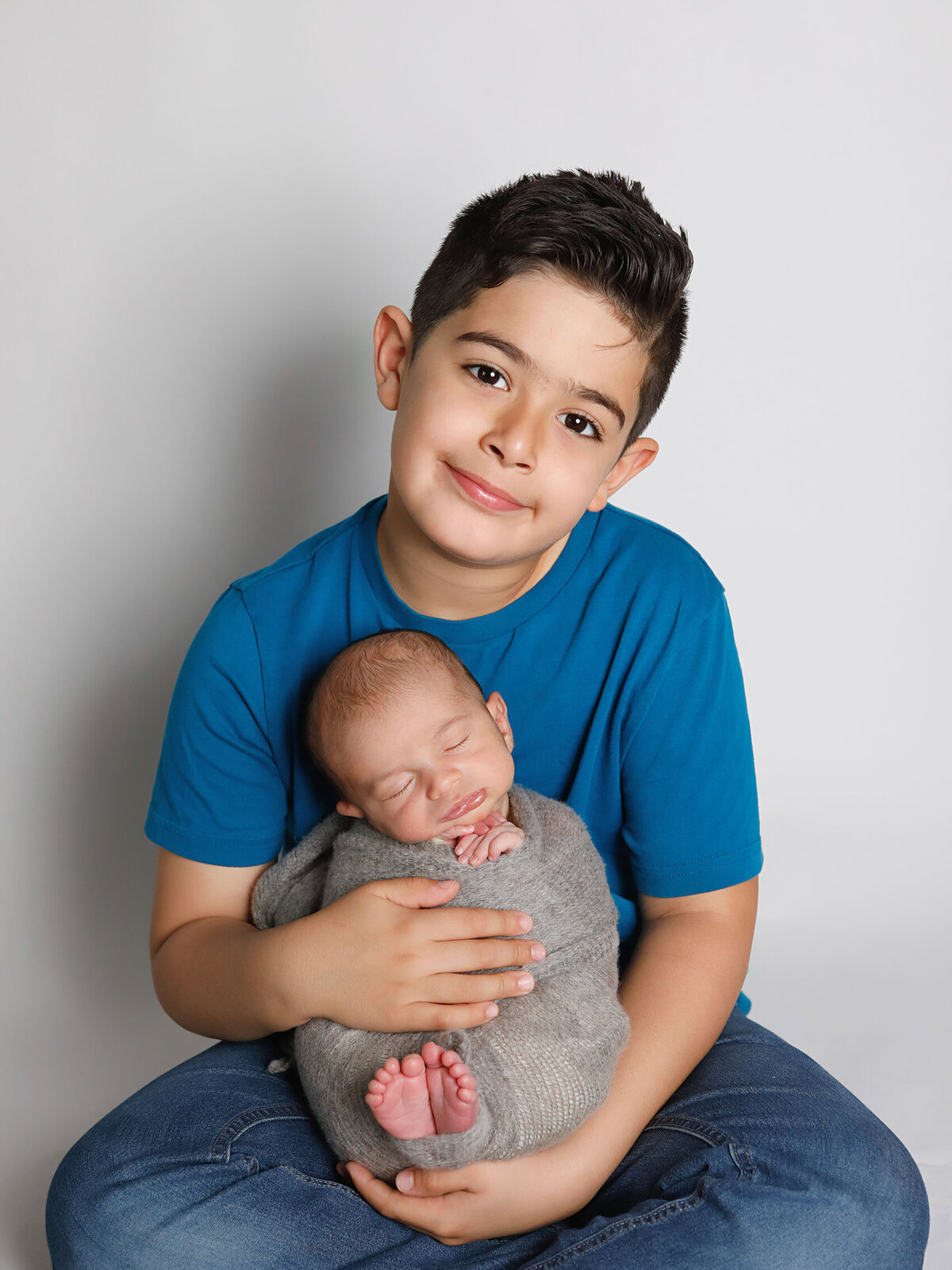 Newborn-photography-session-newborn-wrapped-up-in-brothers-arms-,-newborn-sibling-photo,-photo-taken-by-Janina-Botha-photographer-in-Oakville-Ontario