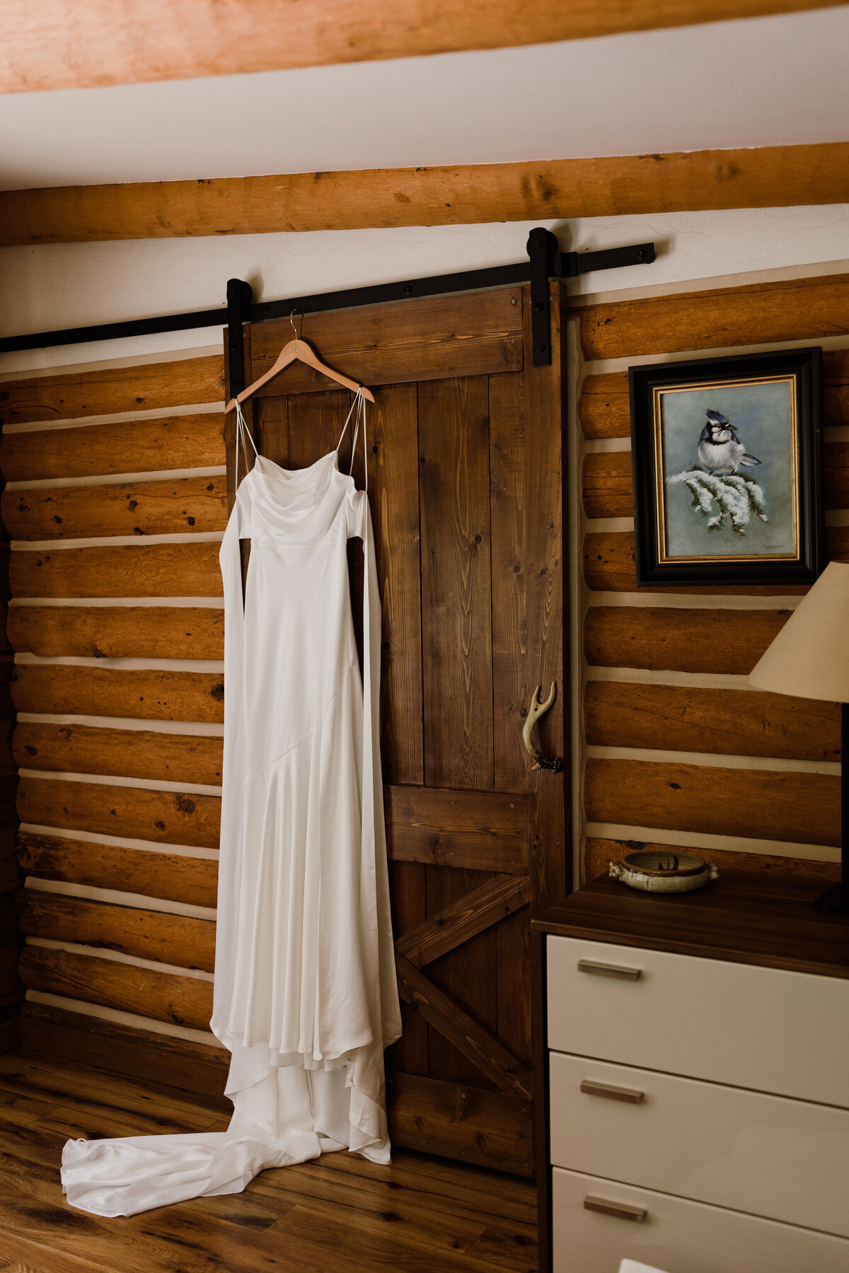 Dress hanging in a cabin at Dallenbach Ranch Colorado Wedding