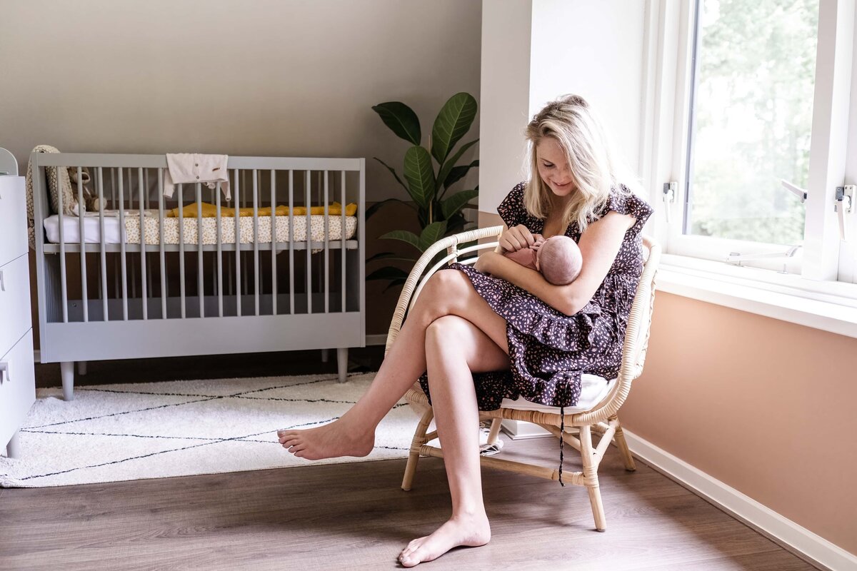 baby fotoshoot Groningen Drenthe en Friesland - moeder en pasgeboren baby in babykamer.