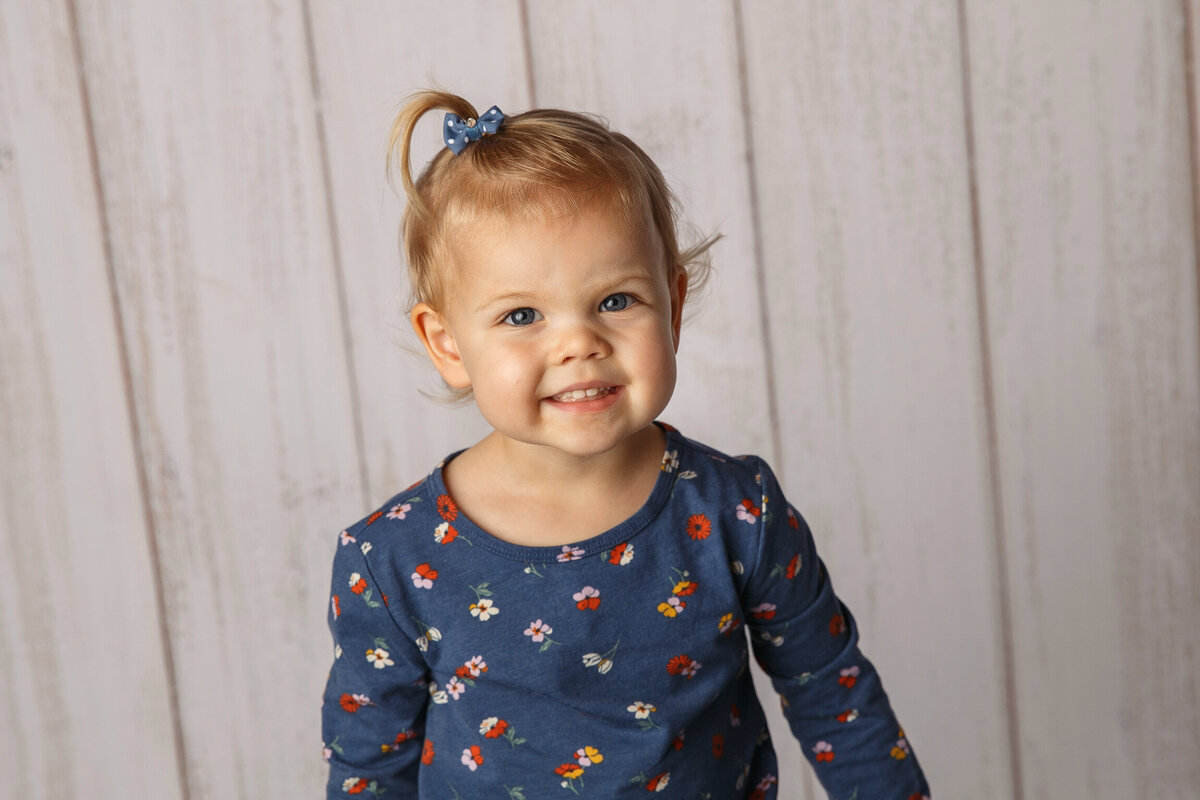 Smiling 3 year old girl in blue print shirt