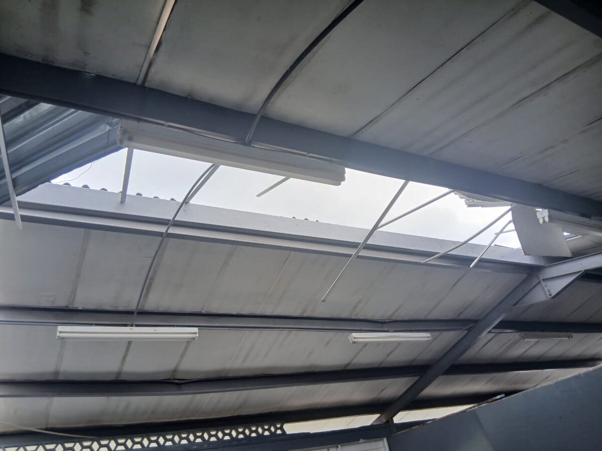 Interior classroom roof severely damaged with large openings caused by Hurricane Melissa.