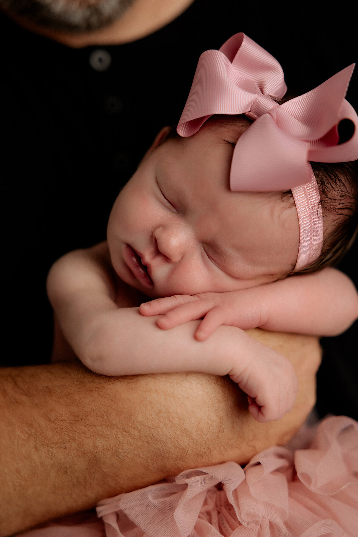 baby girl in daddy's arms dressed in pink