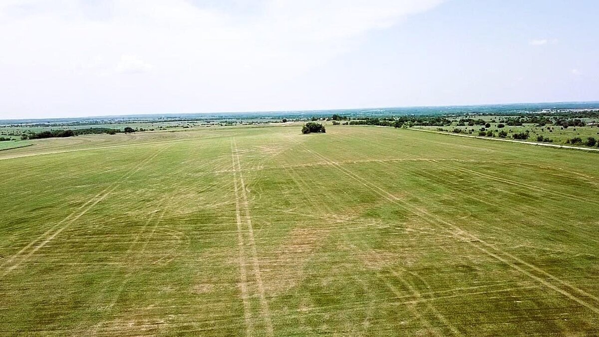 Aerial view of 11-acre property in Lindsay, Texas with open fields and clear skies
