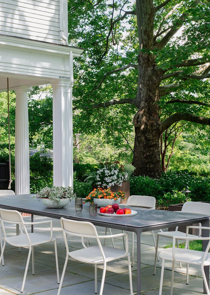 Historic home interior designer in Boston MA creates a modern outdoor dining table, blending sleek design with the charm of a classic New England home.