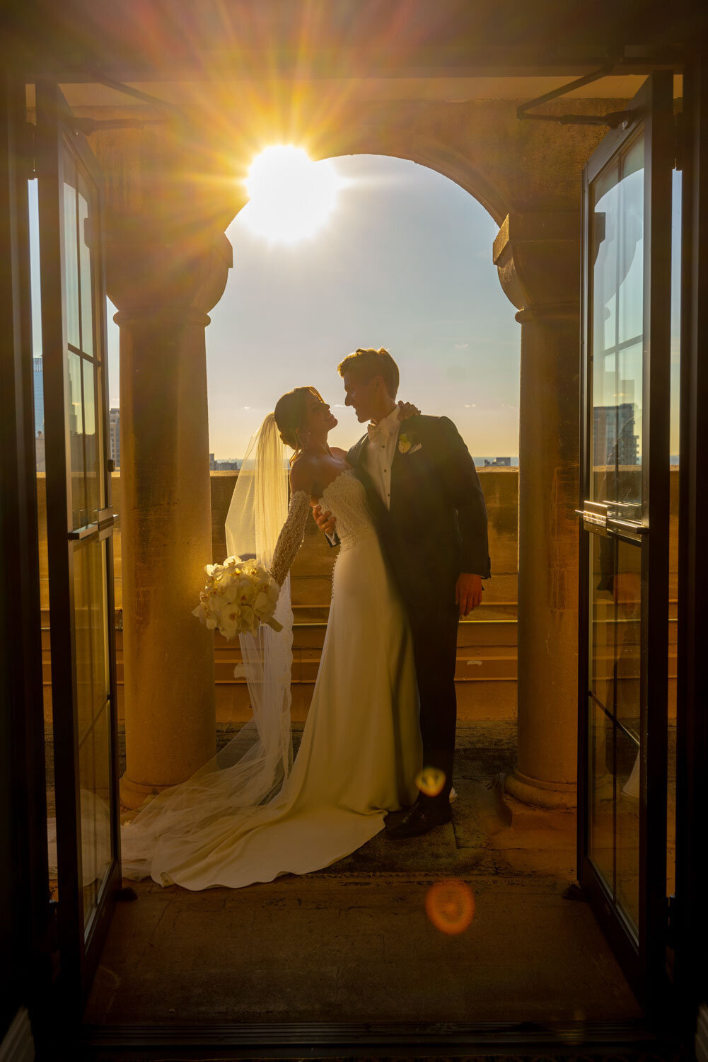 A bride and groom are posing for a picture in a doorway