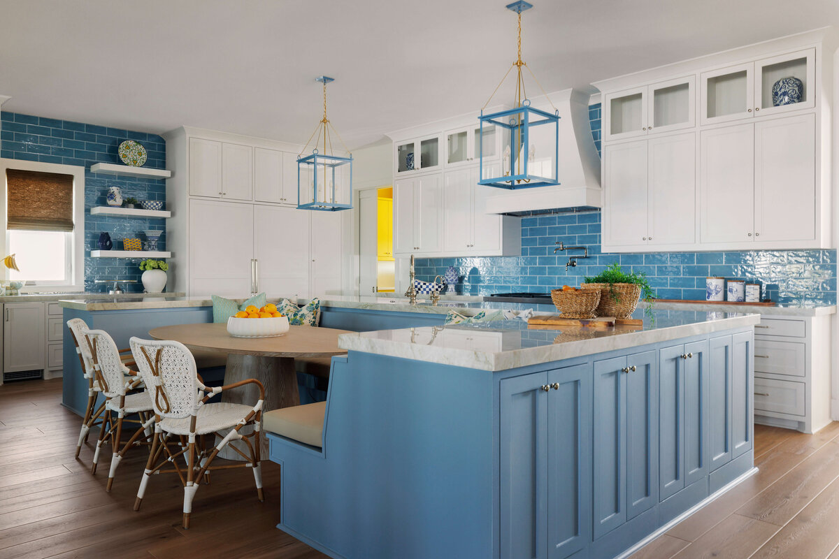 oyster creek studios lighthouse on the lake blue cabinets with bench and white whicker chairs in kitchen