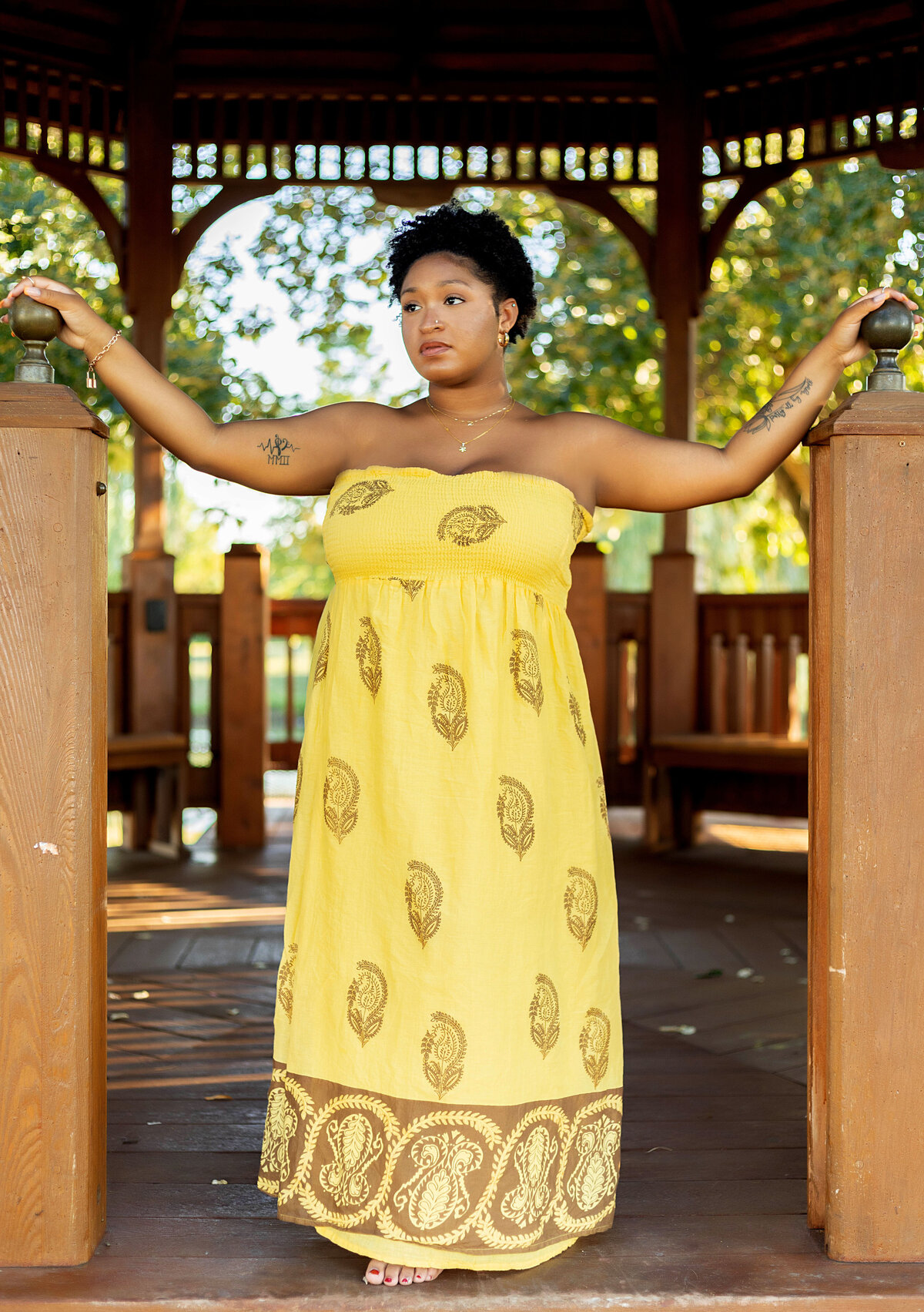 African American woman in yellow sundress standing in gazebo