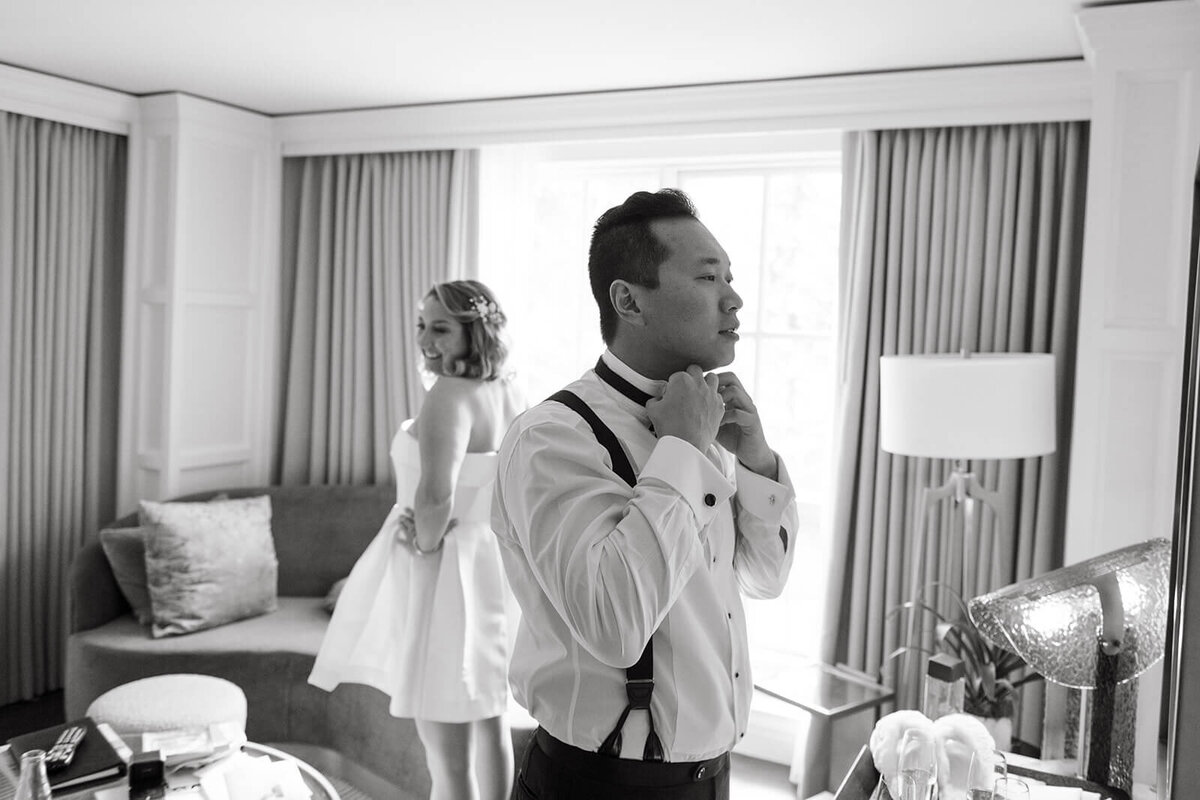 Couple getting ready together at St. Regis Aspen, sharing a romantic moment in a sophisticated suite with elegant decor.