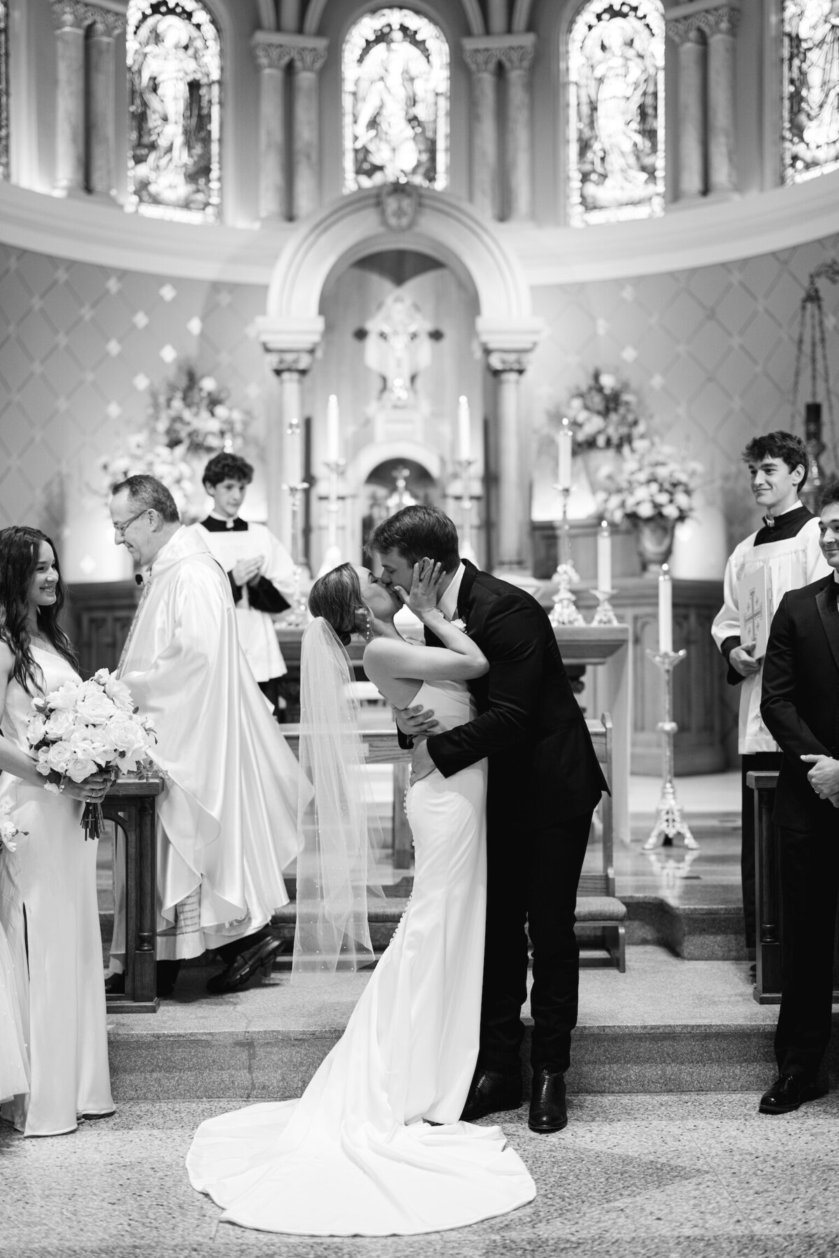 An unforgettable first kiss between bride and groom, captured in classic black and white, preserving the romance of the moment on film by Morgan Alysse, Louisiana film photographer.