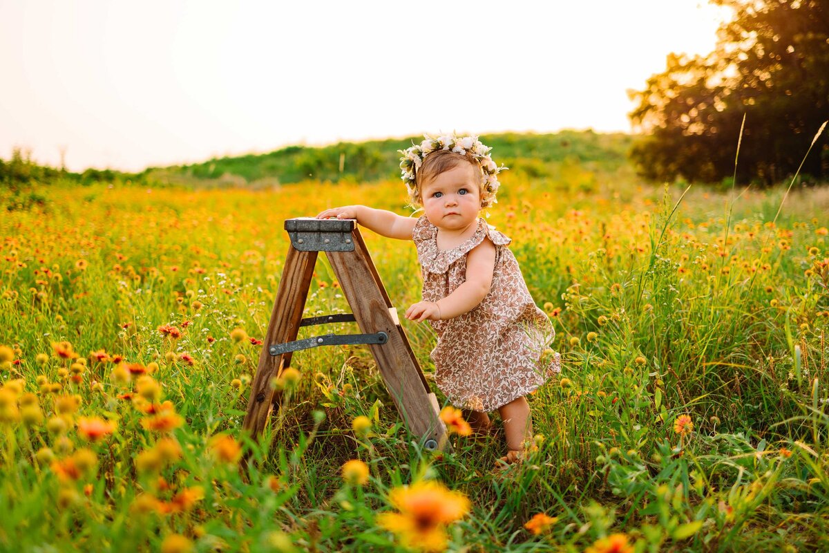 A delightful photograph of a beautiful little girl in a garden, set against a stunning sunset view. The scene is harmonized with vibrant yellow flowers, creating a serene and picturesque moment.