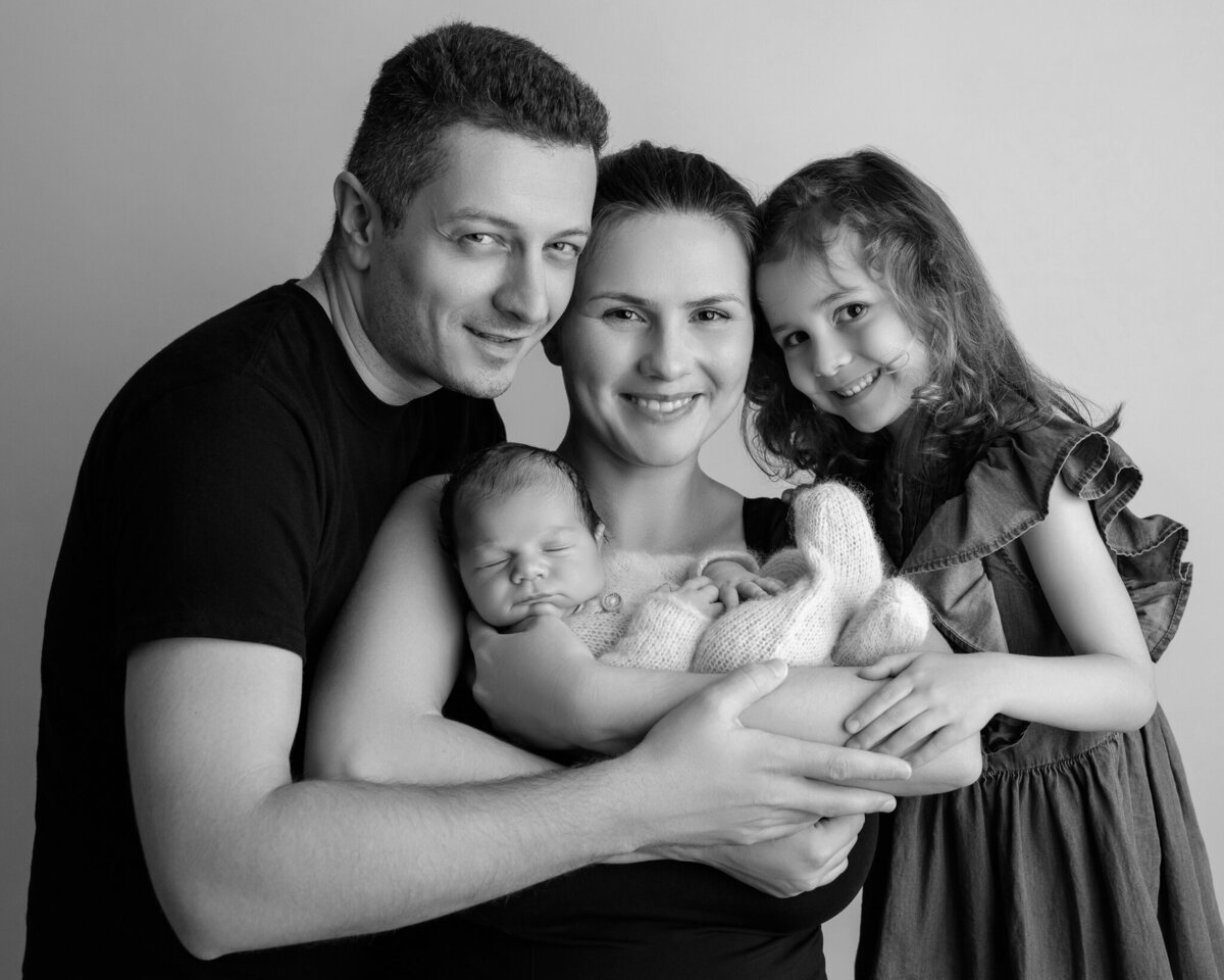 Black and white family portrait with newborn and sibling, smiling together – Leander and Austin newborn photography