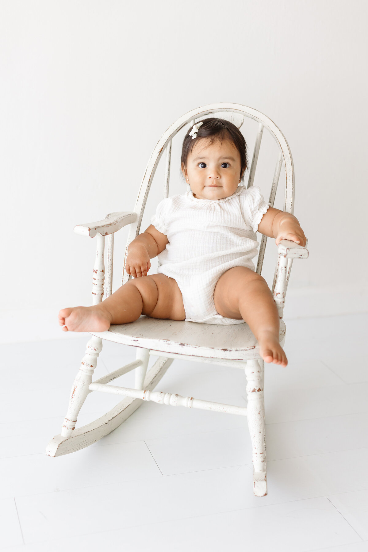 baby girl sitting on rocking chair