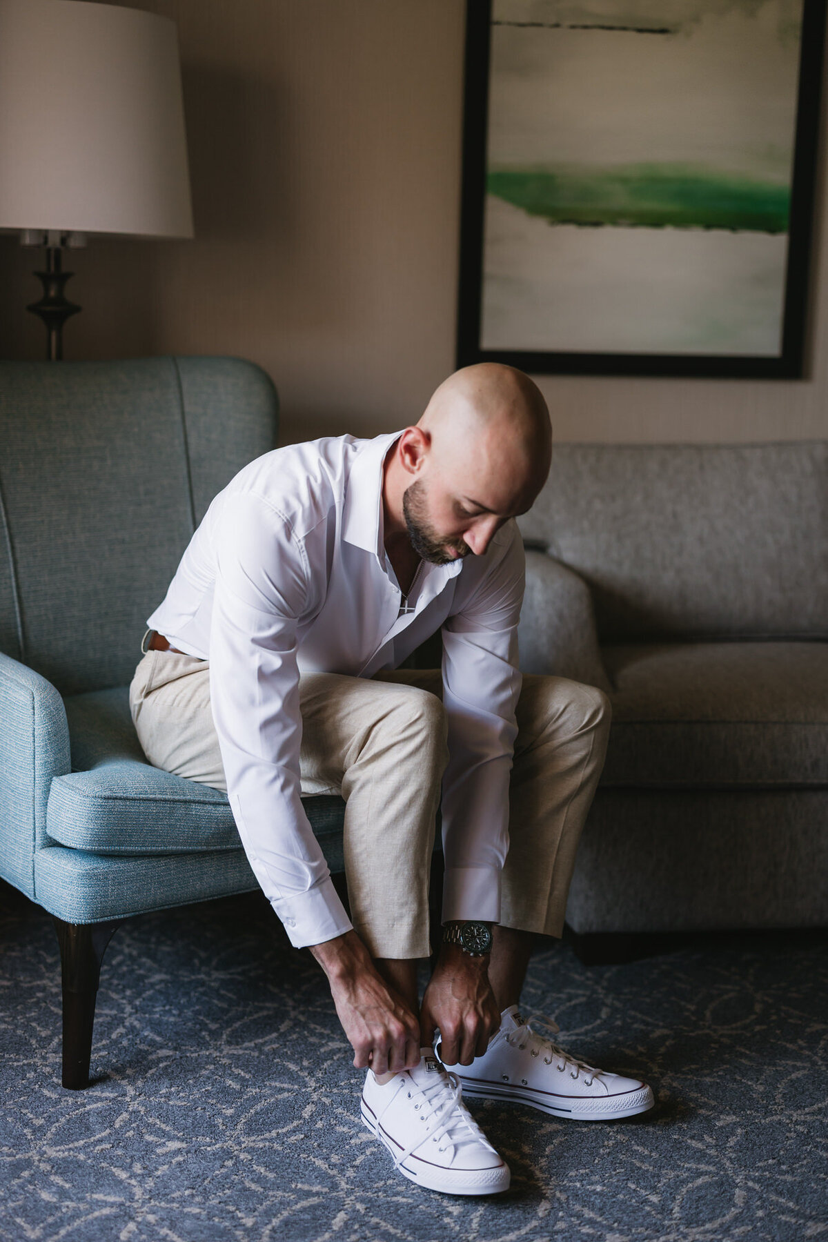 Groom tying shoes while getting ready for wedding at Hilton Beachfront Resort Santa Barbara