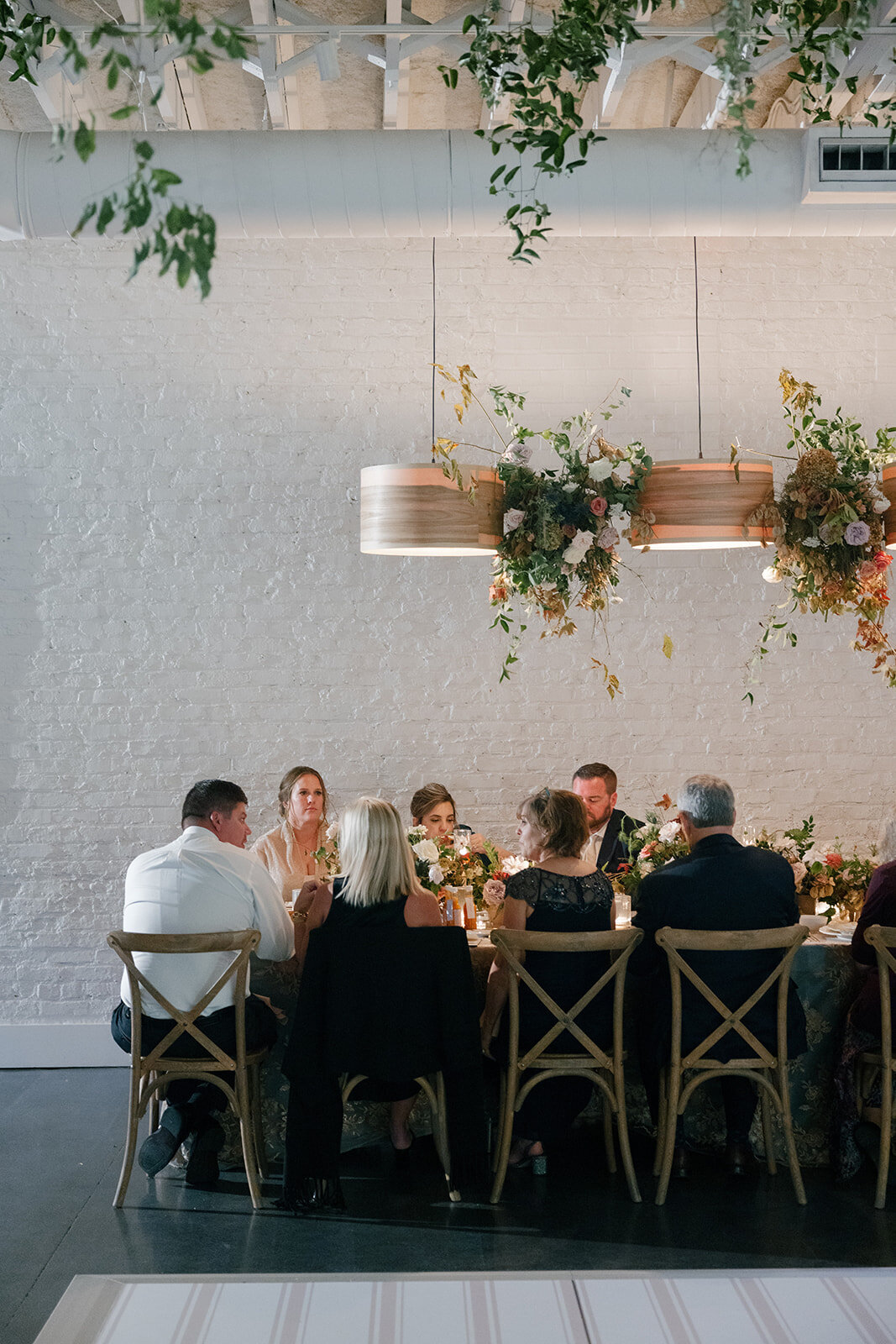 Floral Chandelier hanging floral clouds accent fall wedding reception in Raleigh, NC with roses, hydrangeas, and fall branches in colors of mauve, copper, cream, dusty pink, and green. Design by Rosemary and Finch Floral Design in Nashville, TN.