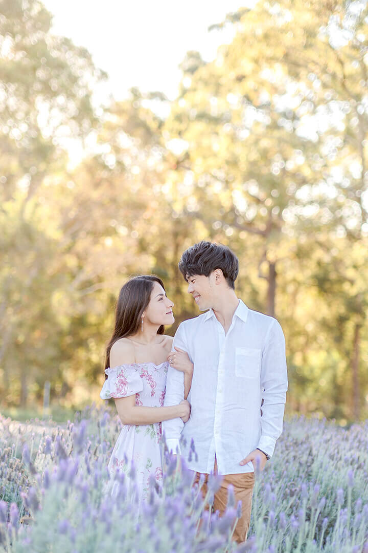 couple hugging in sirromet lavender field having fun with Hikari’s engagement session