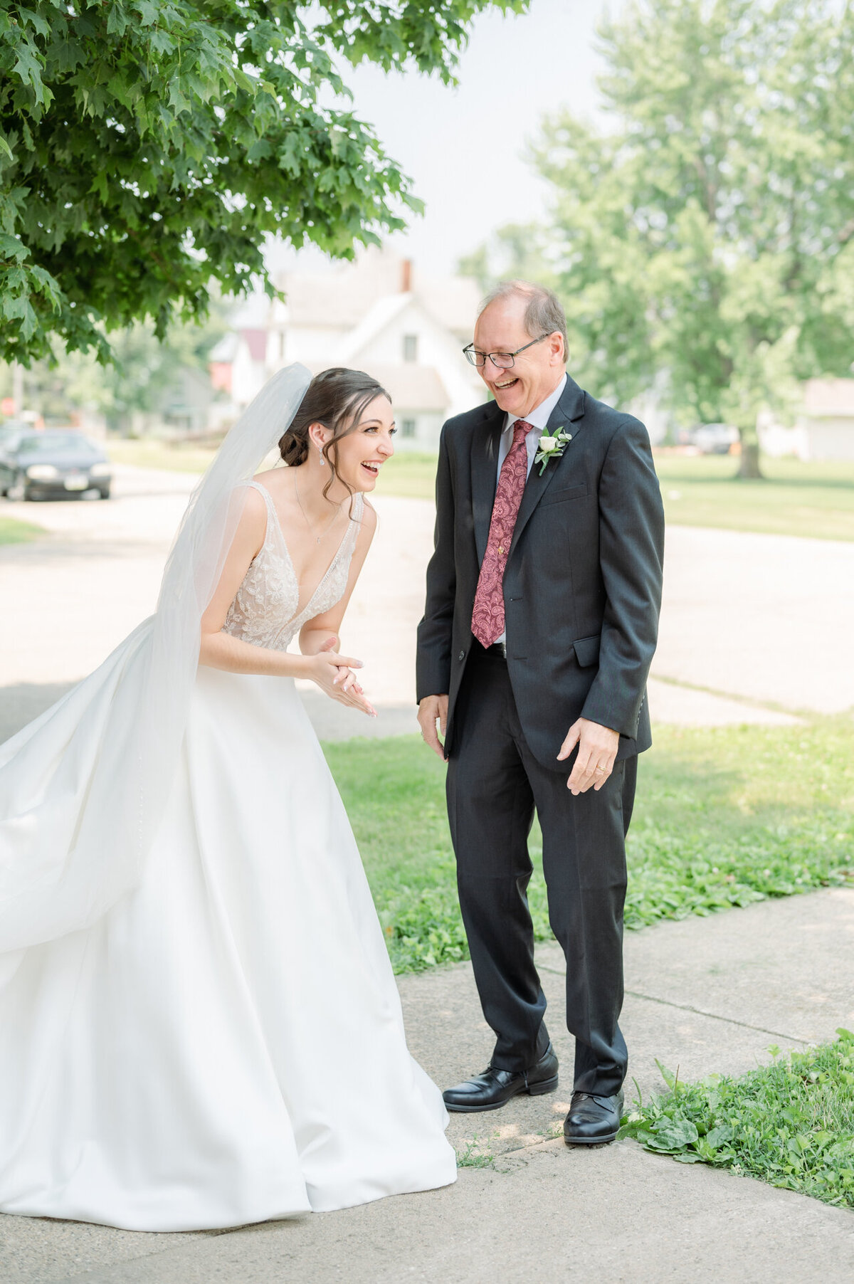 dad and daughter laugh together on wedding day