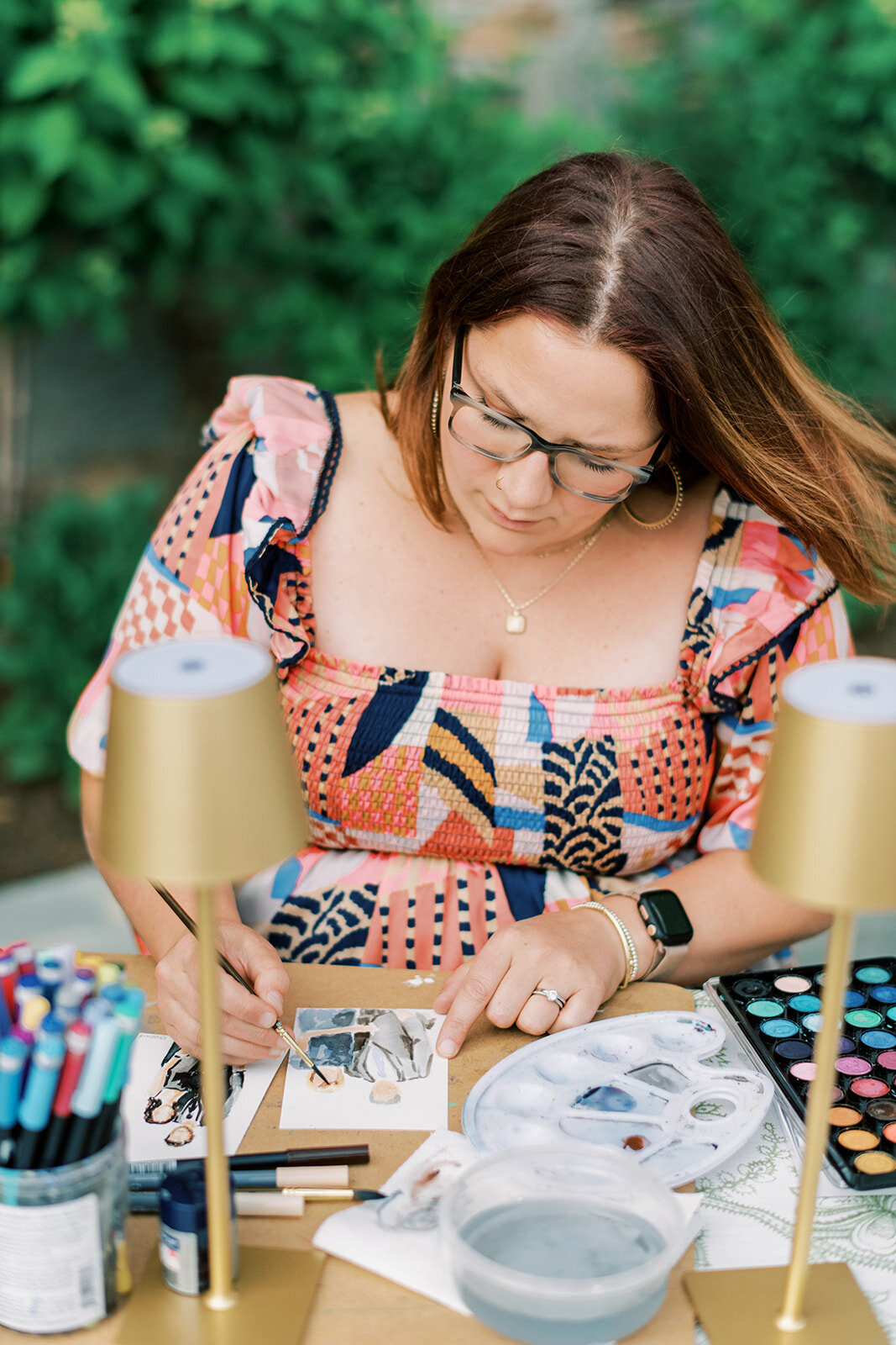 Live watercolor artist painting guest portraits during wedding cocktail hour.
