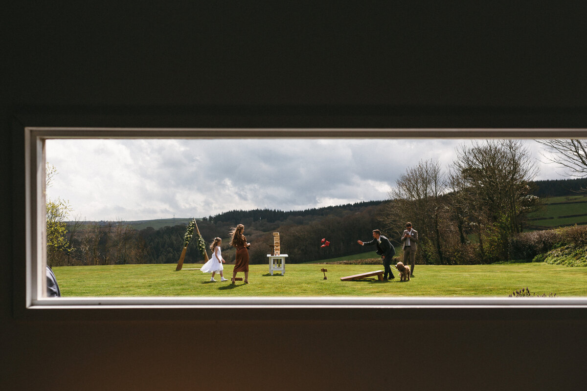 Camel studios guest play lawn games as seen through long window 