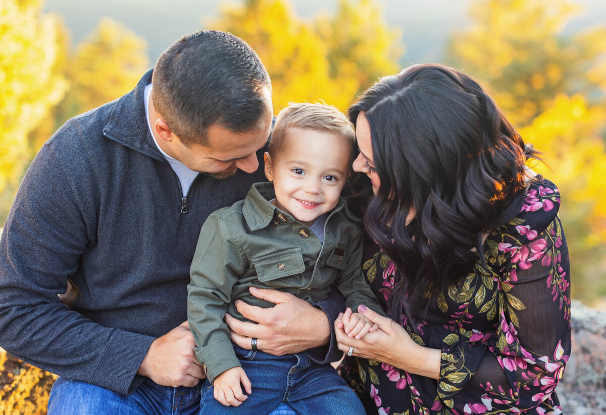 family with young boy smiling for family photos