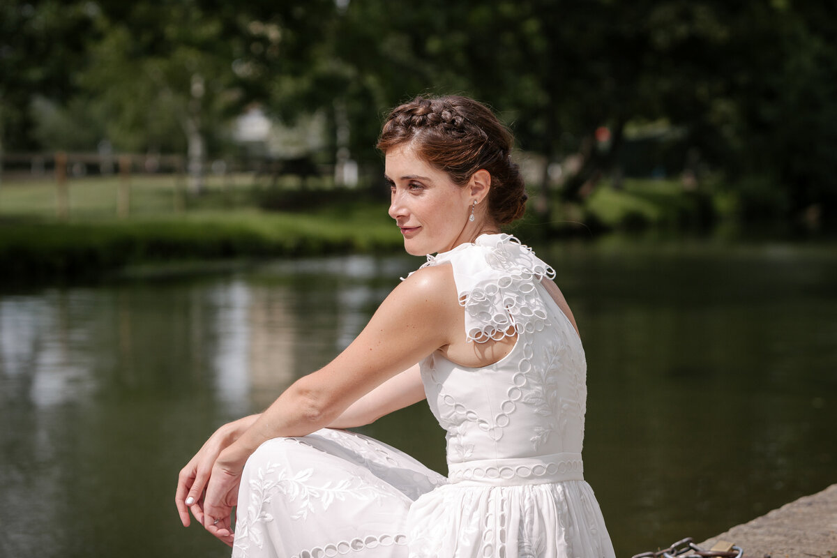 A bride sitting near a river