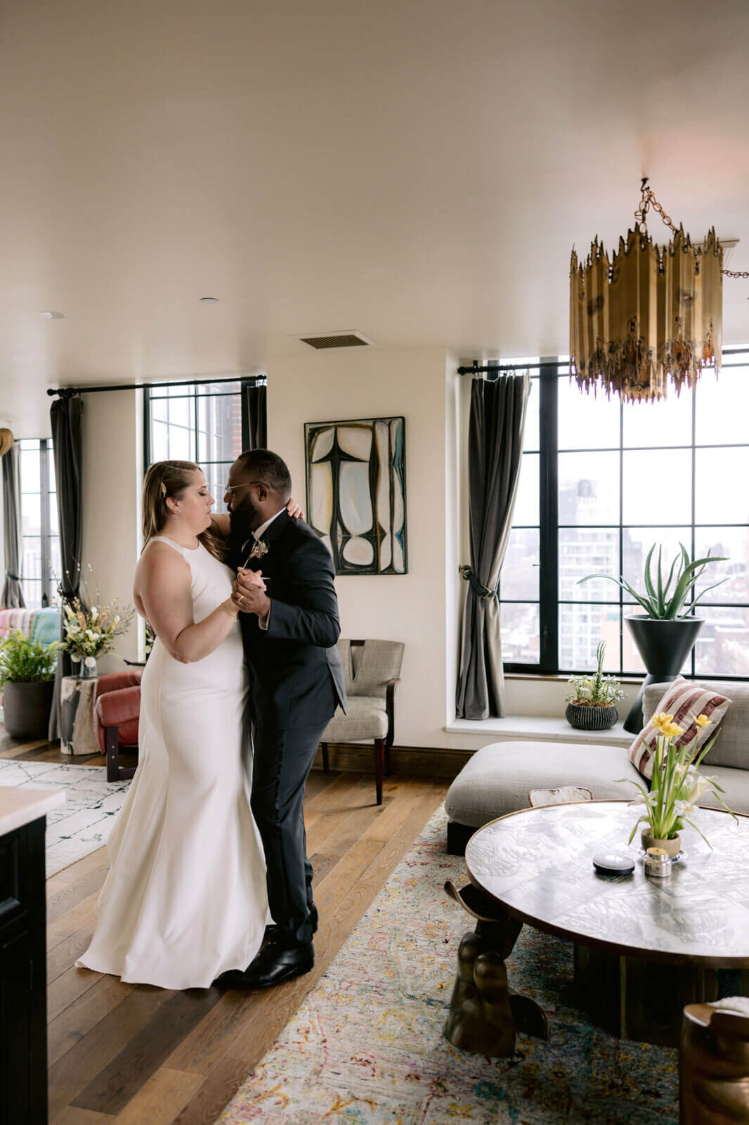 The bride and the groom are dancing inside a Ludlow Hotel room in New York City.
