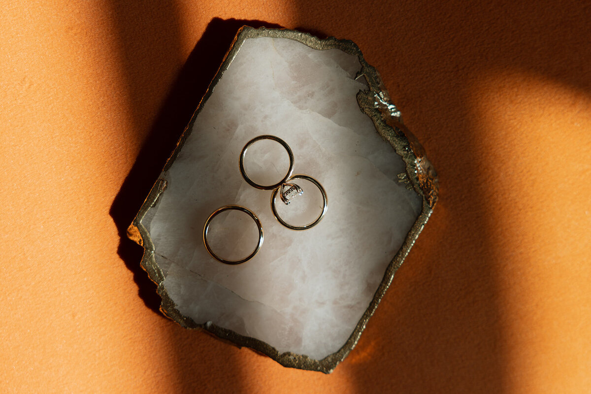 Detail shot of wedding rings placed on a vintage coaster with New York City vibes.