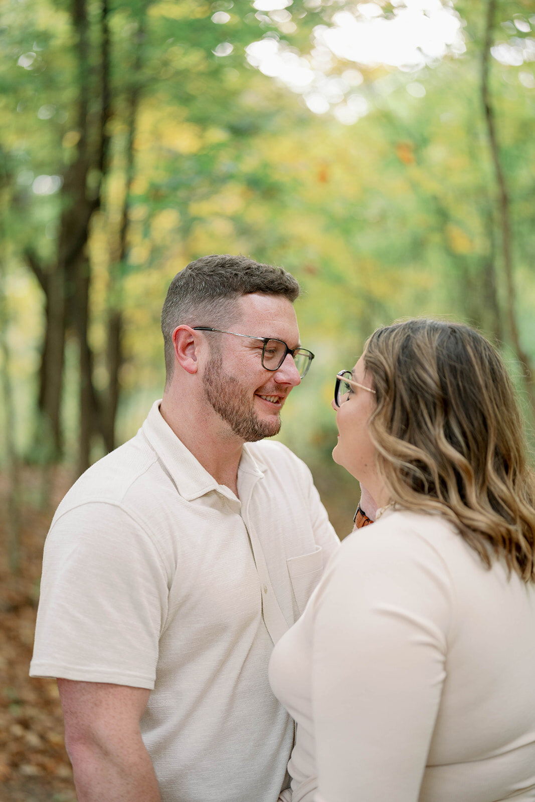 Close-up of the couple smiling at each other during their engagement session in the woods at Al Sabo Preserve.