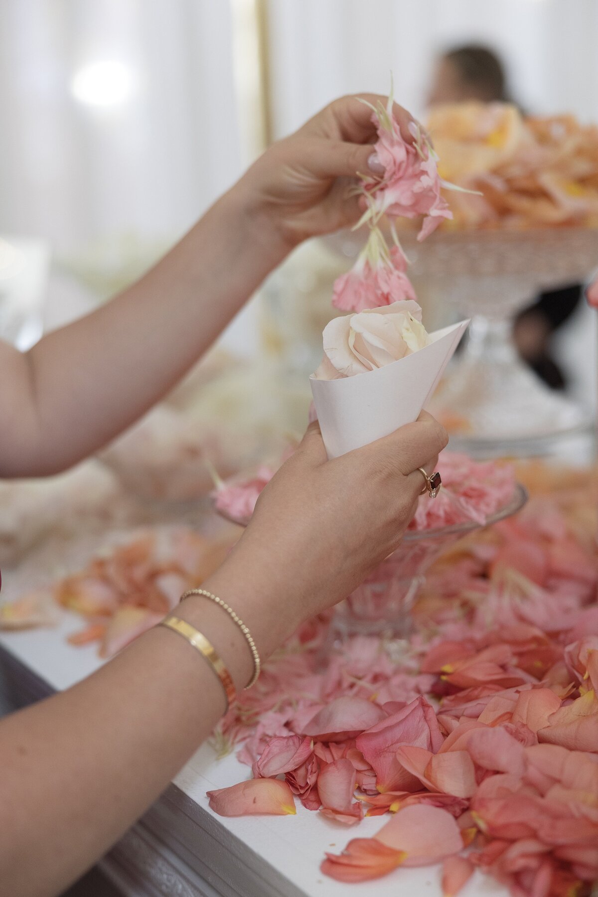 Guest gathers pink petals for ceremony at Belle Mer Newport.