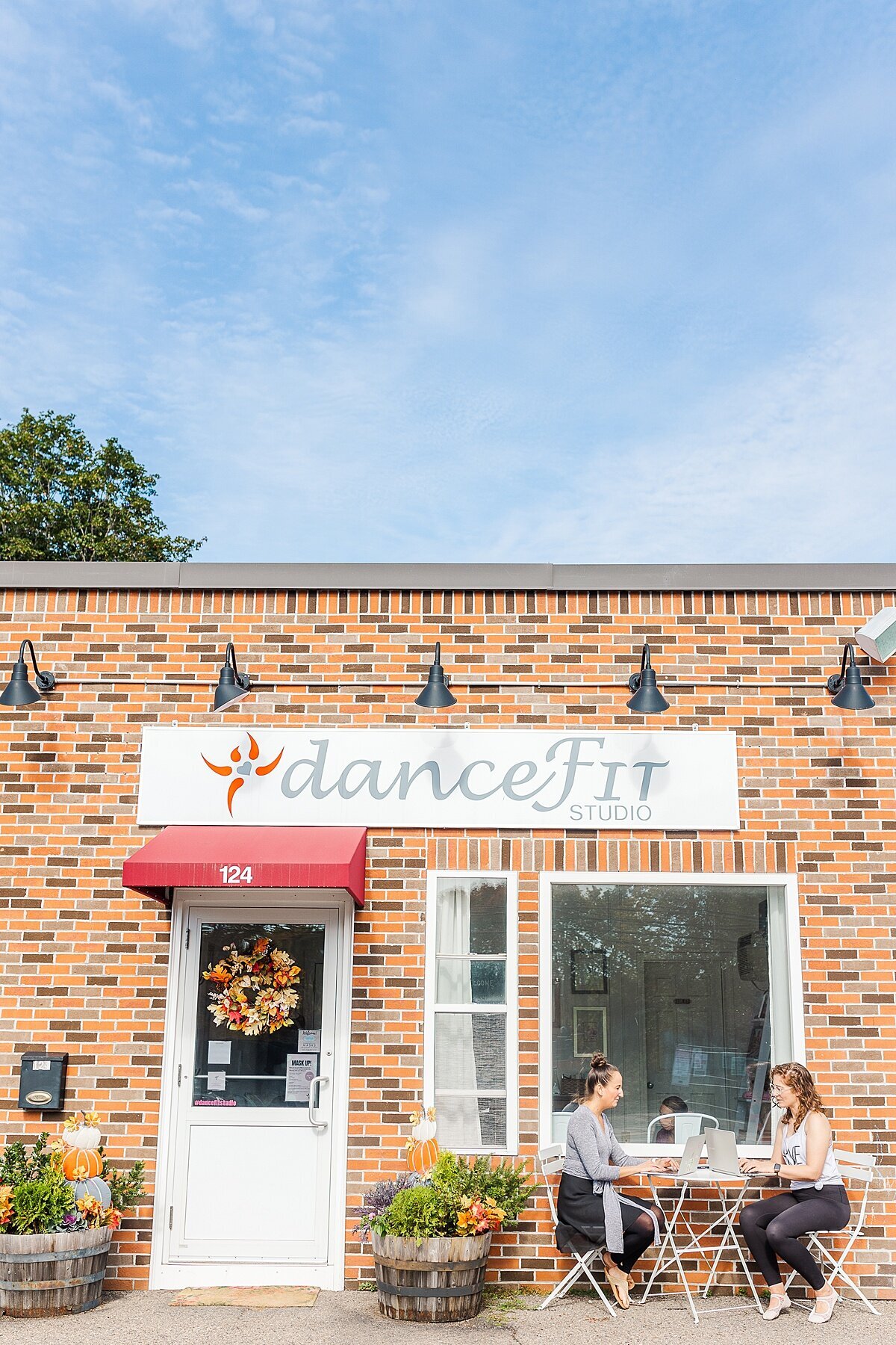 two women sit outside building working during DanceFit Branding photo session with Sara Sniderman Photography in Natick Massachusetts