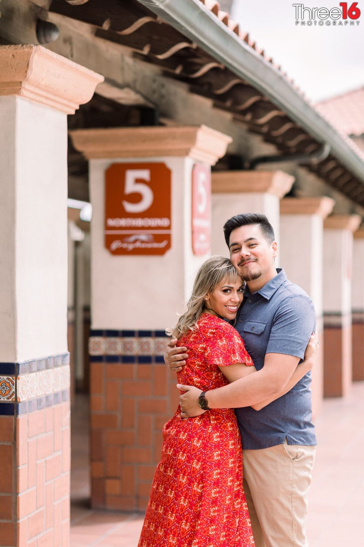 Engaged couple embrace each other on the dock at the Santa Ana Train Station