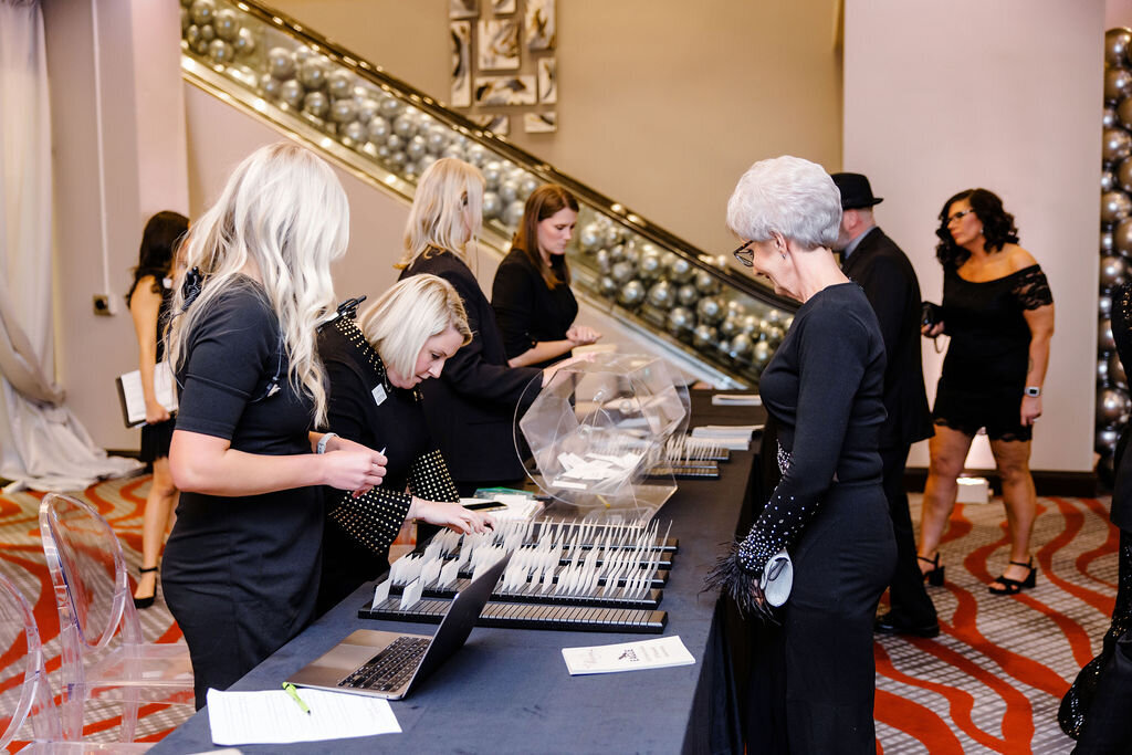 Event staff dressed in black at a table.