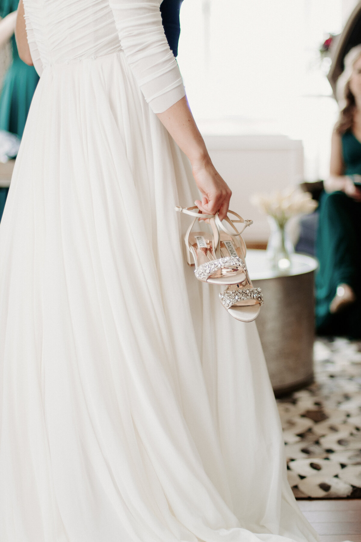 woman in a right dress holding heels in one hand