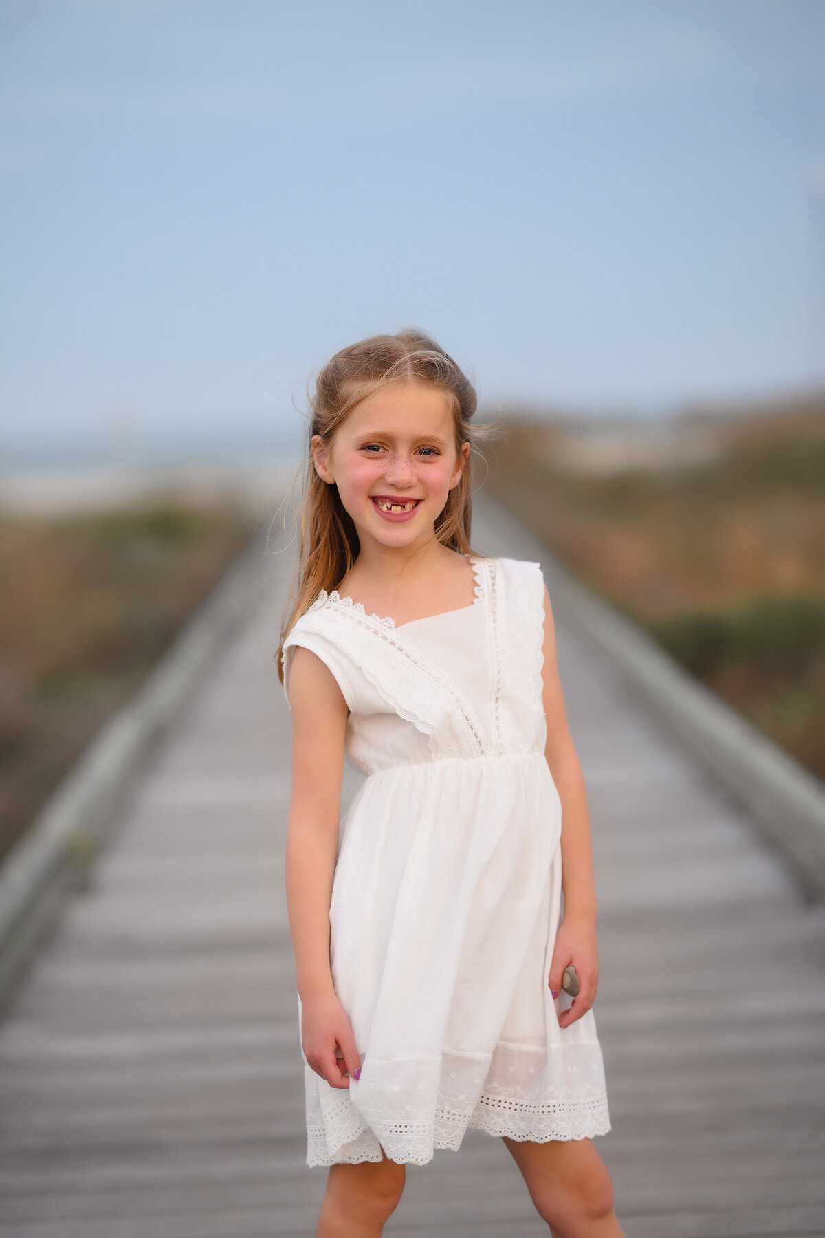 Little girls smiles at the camera during Family Photos on Isle of Palms. 