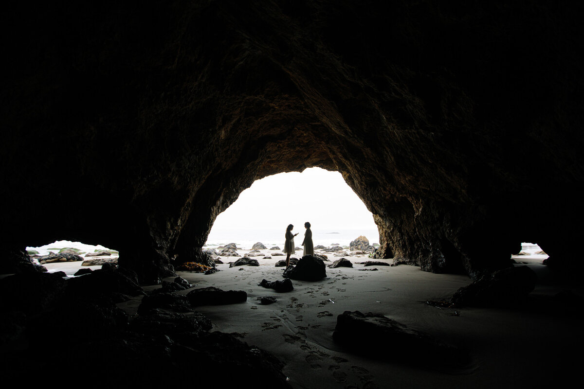 Same sex female couple exchange vows in a sea cave