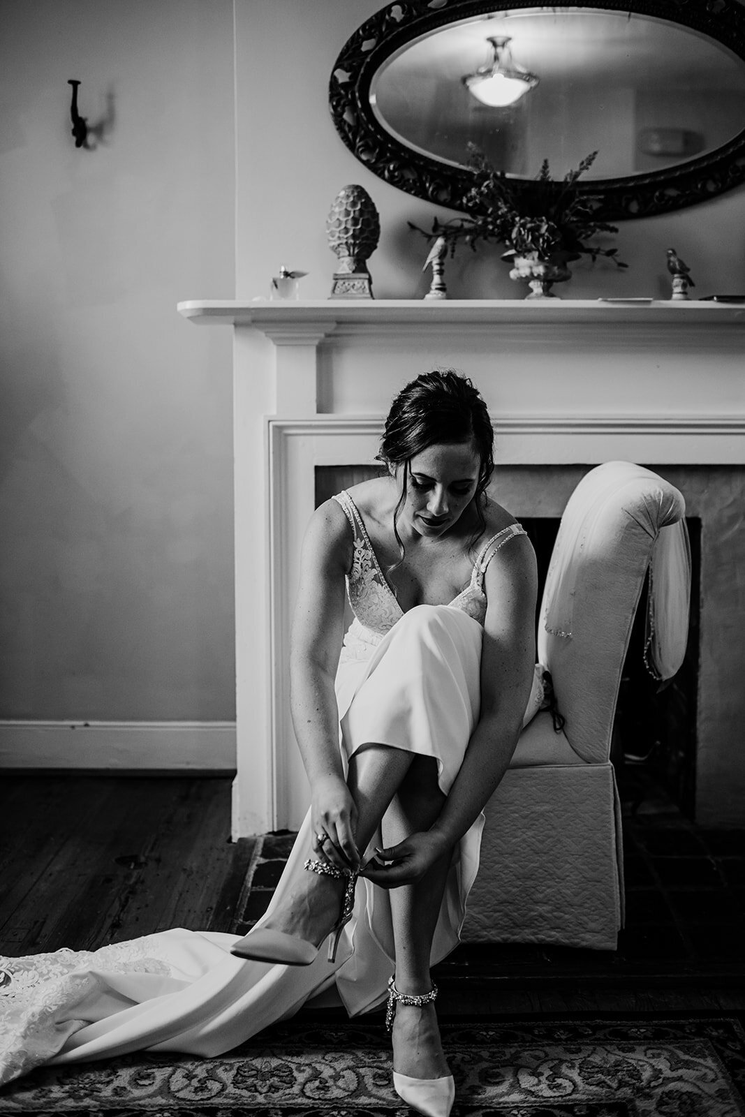 Bride putting on her wedding shoe in black and white