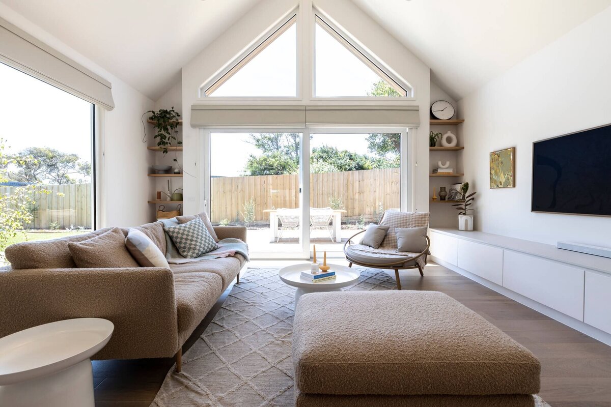 Living room with beige coach and seats with large window at the back