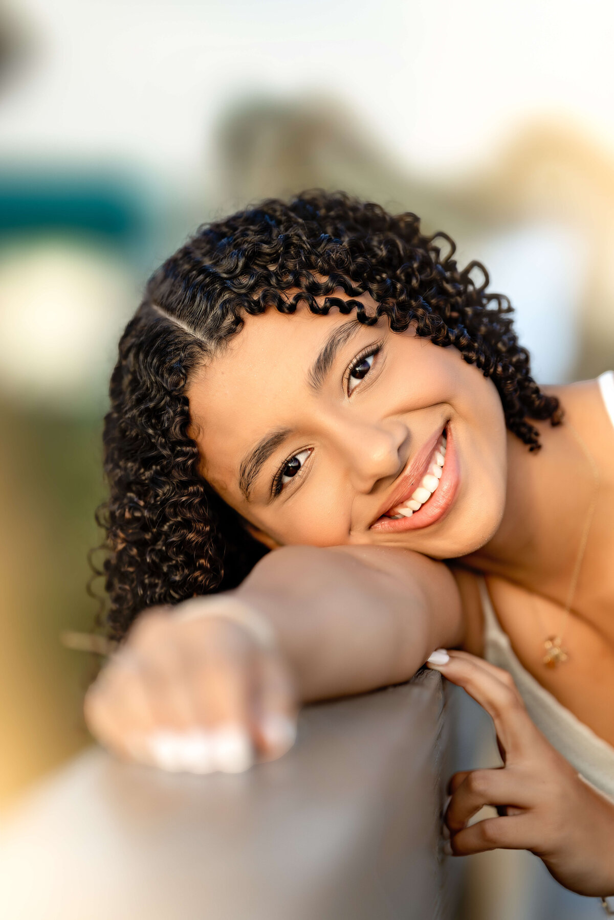Orlando senior photographer capturing a teen girl smiling directly at the camera in a close-up beach portrait.