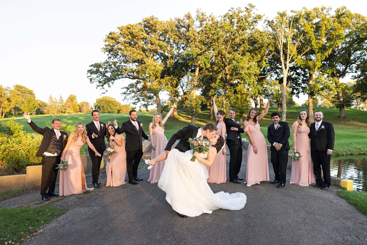 groom-bride-kissing-wedding-party-smiling-outdoor