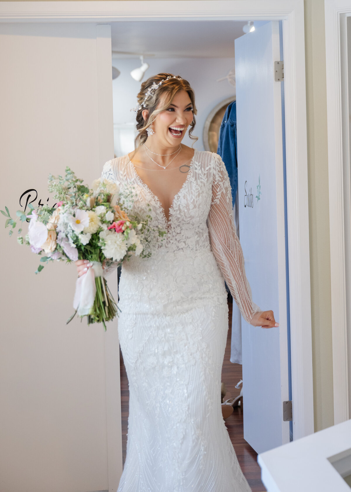 bride first bridal party look at wedding gown indoor suite